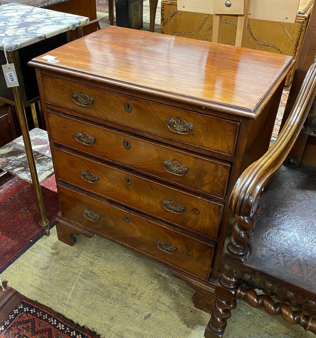 A small George III mahogany chest of four graduating long drawers, raised on bracket supports, replacement handles, width 70cm, depth 43cm, height 78cm